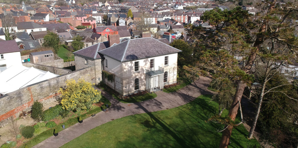 Aerial view of Cardigan Castles historical grounds and surrounding urban landscape in Wales.
