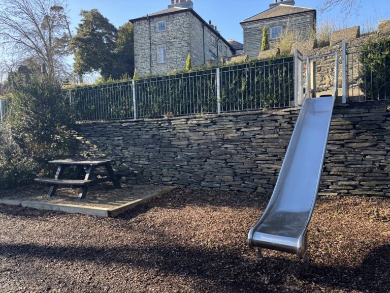 Childrens metal slide and picnic table at Cardigan Castles historic garden setting