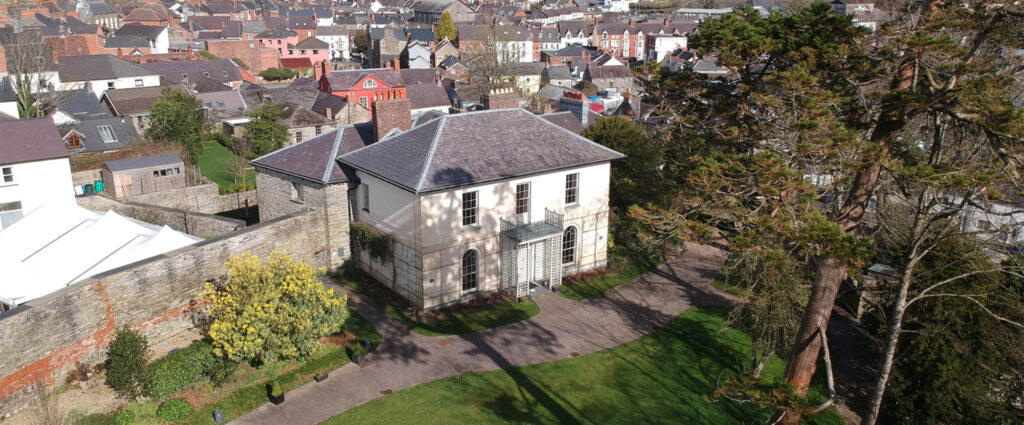 Aerial view of historic Cardigan Castle with surrounding gardens and the town landscape