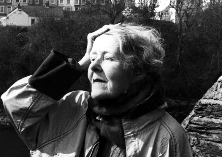 Elderly woman enjoying a scenic view near Cardigan Castle, Wales, in black and white photograph